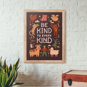 May include: A framed poster with a brown background and the words "BE KIND TO EVERY KIND" in white. The poster features illustrations of various animals, including a chicken, pig, cat, dog, cow, and sheep, in a whimsical style.