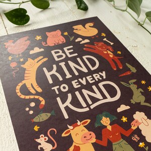 May include: A dark brown poster with the words "BE KIND TO EVERY KIND" in large, cream-colored letters. The poster features illustrations of various animals, including a cat, dog, pig, and sheep, in a whimsical style.