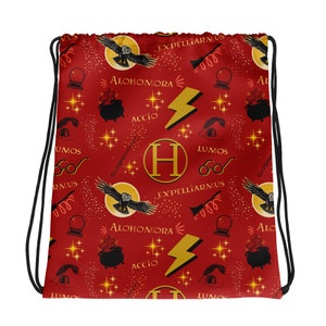 May include: Red drawstring bag with a repeating pattern of Harry Potter themed icons, including a golden 'H', owls, wands, stars, and the spells 'Accio', 'Lumos', 'Expeliarmus', and 'Alohomora'.