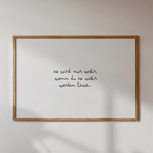 Könnte beinhalten: Ein gerahmter weißer Druck mit dem deutschen Text "es wird nur wahr, wenn du es wahr werden lässt..." in schwarzer Schrift. Der Rahmen besteht aus hellbraunem Holz und ist rechteckig.