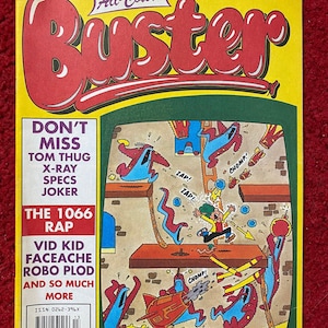 Pode incluir: Uma capa de banda desenhada vintage "Buster" com fundo amarelo e um grande título vermelho. A capa apresenta ilustrações de desenhos animados coloridos de cenas de ação e texto, incluindo "Don't Miss" e "The 1066 Rap".