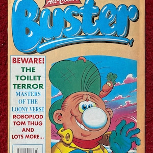 Pode incluir: Uma capa de banda desenhada vintage com uma personagem de desenho animado com um nariz grande e um chapéu verde. A capa é intitulada "Buster" e apresenta o texto "Cuidado! O terror do toalete, Os mestres do Loony Verse, Roboplod, Tom Thug e muito mais..."