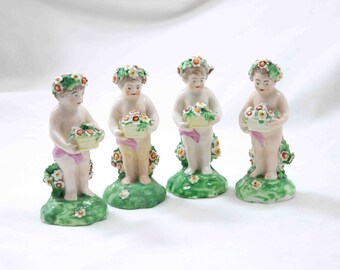 Precioso conjunto de 4 figuras antiguas de flores infantiles querubines sosteniendo una cesta de flores