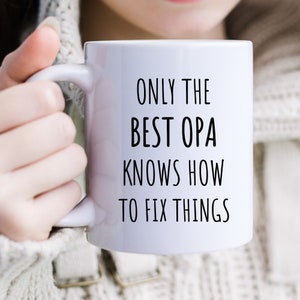May include: White ceramic mug with black text that reads "Only the best Opa knows how to fix things".