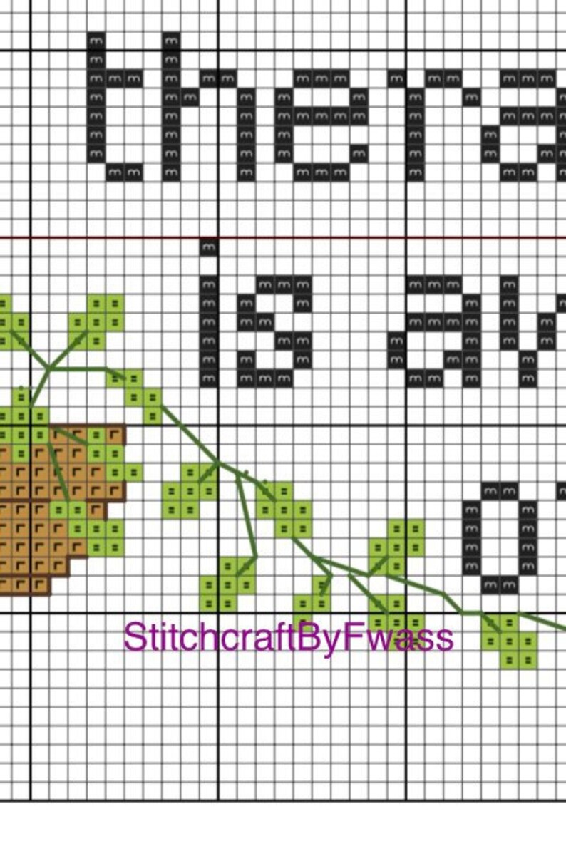 May include: Cross stitch pattern featuring a brown acorn with green leaves and the text "Dream Big" in black.