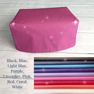 May include: A close-up of a pink fabric with a glittery texture. The fabric is folded into a rectangular shape. The text "Black, Blue, Light Blue, Purple, Lavender, Pink, Red, Coral, White" is written below the fabric.