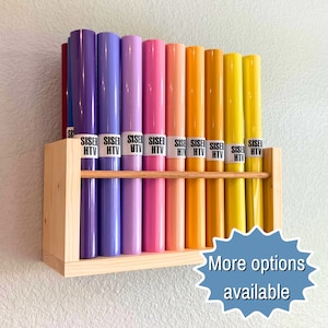 May include: A wooden shelf with 12 rolls of heat transfer vinyl in various colors, including purple, pink, yellow, and orange. The rolls are labeled "Siser HTV".