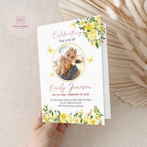 May include: A white memorial card with a yellow floral border and a photo of a woman. The text reads "Celebrating the Life of Emily Jameson July 15, 1986 - February 18, 2025 On Saturday, February 22th 2025 at 10am The St. Mary's Church 156 Princess Hwy, Sydney"