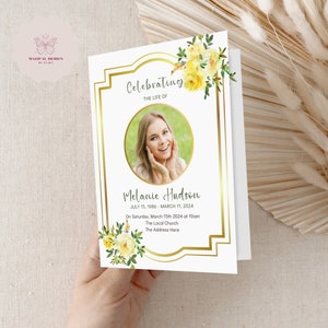 May include: A white memorial card with a gold frame and yellow floral accents. The card features a photo of a woman and the text "Celebrating the Life of Melanie Hudson July 15, 1986 - March 11, 2024 On Saturday, March 15th 2024 at 10am The Local Church The Address Here"