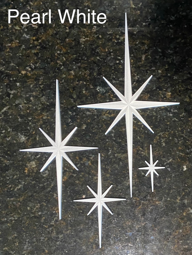 May include: Four white starburst shapes on a dark gray background. The text "Pearl White" is at the top of the image.