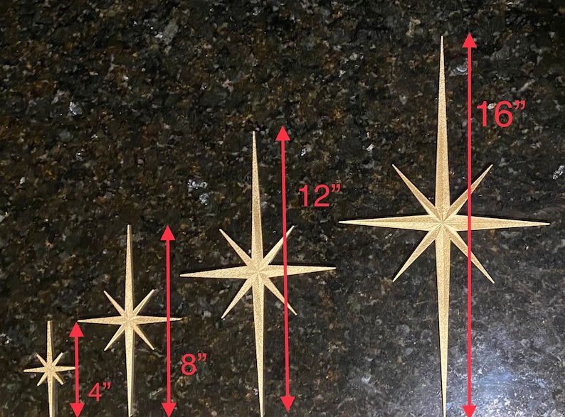 May include: Four gold starburst ornaments of varying sizes. The smallest is 4 inches tall, the next is 8 inches tall, the next is 12 inches tall, and the largest is 16 inches tall.