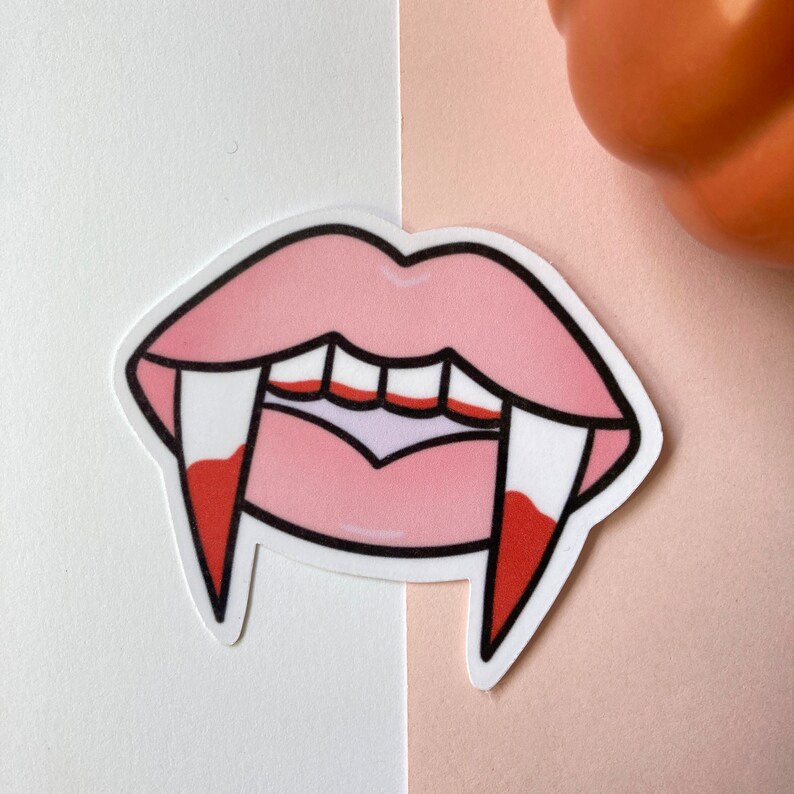 May include: A pink and red vampire mouth sticker with fangs and dripping blood.