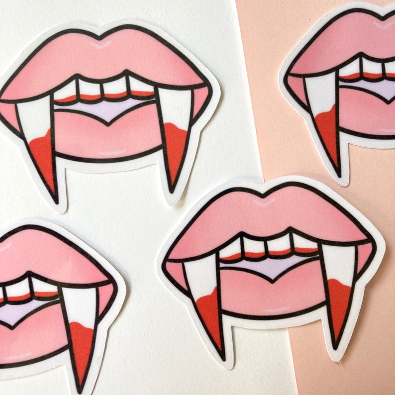 May include: Four pink and white vampire mouth stickers with fangs. The stickers are on a white and pink background.