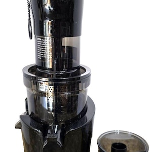 May include: A black juicer with a separate pulp container. The juicer has a cylindrical design with a spout and a top section with a handle. The pulp container is clear with a black handle. The juicer is designed for extracting juice from fruits and vegetables.
