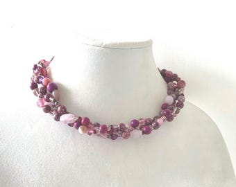 Elegante collar ajustable de varios tonos de rojo para cubrir una cicatriz en el cuello.
