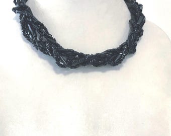 Elegante collar negro retorcido para cubrir la cicatriz del cuello.