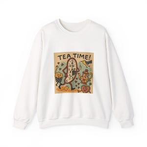Puede incluir: Sudadera blanca con un gráfico colorido que dice "TEA TIME!". El gráfico presenta un reloj, una magdalena, una tetera, un corazón y un pájaro. El diseño tiene un estilo vintage de dibujos animados.