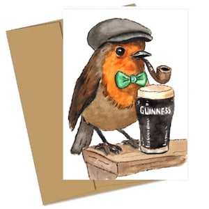 May include: Watercolor illustration of a robin bird wearing a flat cap and green bow tie, smoking a pipe, and holding a pint of Guinness. The card is paired with a brown envelope.