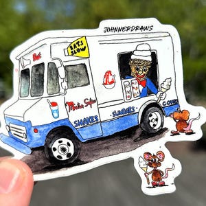 May include: A sticker featuring a whimsical ice cream truck illustration. The truck is white and blue, with the text "Mister Softee" and "Shakes & Sundaes." A clown figure sells ice cream cones. Two cartoon mice are also present.