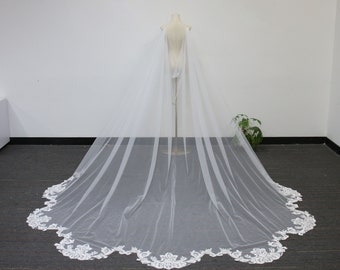 May include: A white tulle wedding veil with a lace trim. The veil is long and flowing, and it is perfect for a bride who wants a classic and elegant look.