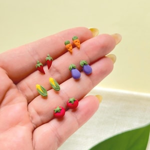 Peut inclure: Boucles d'oreilles miniatures en forme de légumes, comprenant des piments rouges, des carottes oranges, des aubergines violettes, du maïs jaune et des tomates rouges. Ces boucles d'oreilles petites et colorées sont parfaites.