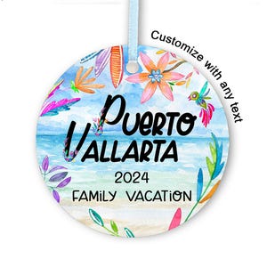 Könnte beinhalten: Ein runder, weißer Weihnachtsbaumschmuck mit einem Aquarell-Design einer Strandszene. Der Schmuck zeigt ein blaues Meer, weißen Sand und bunte Blumen und Blätter. Der Text "Puerto Vallarta 2024 Family Vacation" ist auf dem Schmuckstück aufgedruckt.