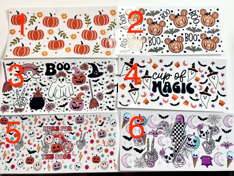 May include: Six different Halloween themed sticker sheets with various designs. The designs include pumpkins, ghosts, bats, skulls, and other Halloween imagery. The sticker sheets are all white with black and orange designs.