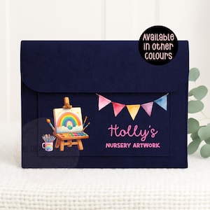 May include: A navy blue felt artwork portfolio with a flap closure. The front features a watercolour painting of a rainbow on an easel, paintbrushes, and a paint palette. The text "Holly's Nursery Artwork" is displayed below a banner of colourful flags.