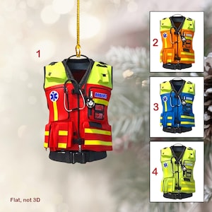 Könnte beinhalten: Eine rote, gelbe und schwarze Sicherheitsweste mit einem Stethoskop, einem Namensschild mit der Aufschrift "ROBERT" und einem Stern-des-Lebens-Symbol. Die Weste ist ein Weihnachtsornament.
