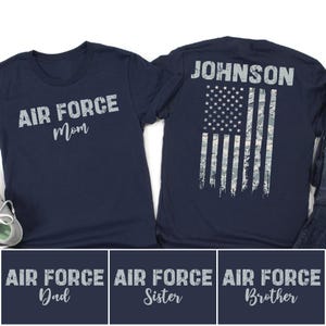 May include: Navy blue t-shirts with white text. One shirt says "AIR FORCE Mom" and the other has an American flag design with the name "JOHNSON". Below are three more shirts that say "AIR FORCE Dad", "AIR FORCE Sister", and "AIR FORCE Brother".
