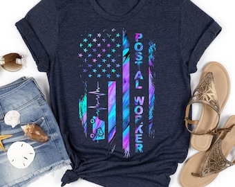 May include: A navy blue t-shirt with a colorful American flag design. The flag is a gradient of blue, purple, and pink. The text "POSTAL WORKER" is printed vertically on the right side of the flag.