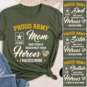 May include: An olive green t-shirt featuring yellow and white text that reads PROUD ARMY Mom MOST PEOPLE NEVER MEET THEIR Heroes I RAISED MINE. The design includes a U.S. Army star logo and a heart graphic with a thin yellow line inside.