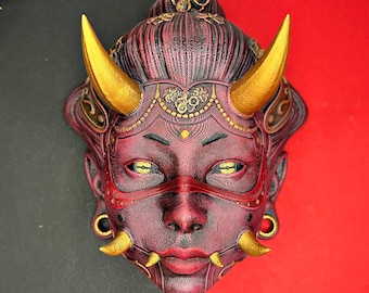 May include: A red and gold mask with horns, intricate details, and a fierce expression. The mask is in a traditional Japanese style.