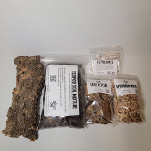 May include: A set of isopod terrarium supplies, including a bag of isopod soil mixture, a bag of leaf litter, a bag of sphagnum moss, a piece of cork bark, and a bag of cuttlebones. The bags are labeled with the name of the product and the brand "Critters Cave".