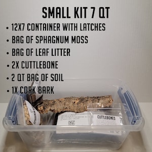 May include: A clear plastic container with a blue latch, filled with a reptile habitat kit. The kit includes a bag of sphagnum moss, a bag of leaf litter, two pieces of cuttlebone, a bag of soil, and a piece of cork bark. The container is labeled "SMALL KIT 7 QT".