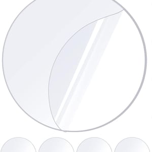 May include: A clear, circular sticker with a peeled-back corner, revealing a transparent layer beneath. Below, four additional clear, circular stickers are visible, suggesting a set or multiple uses. The design is simple and functional.