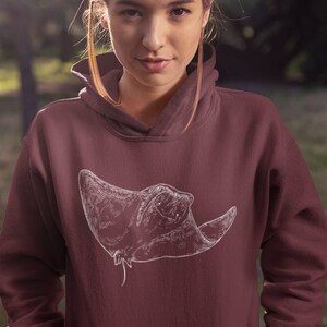 May include: A maroon hoodie with a white outline drawing of a stingray on the front.