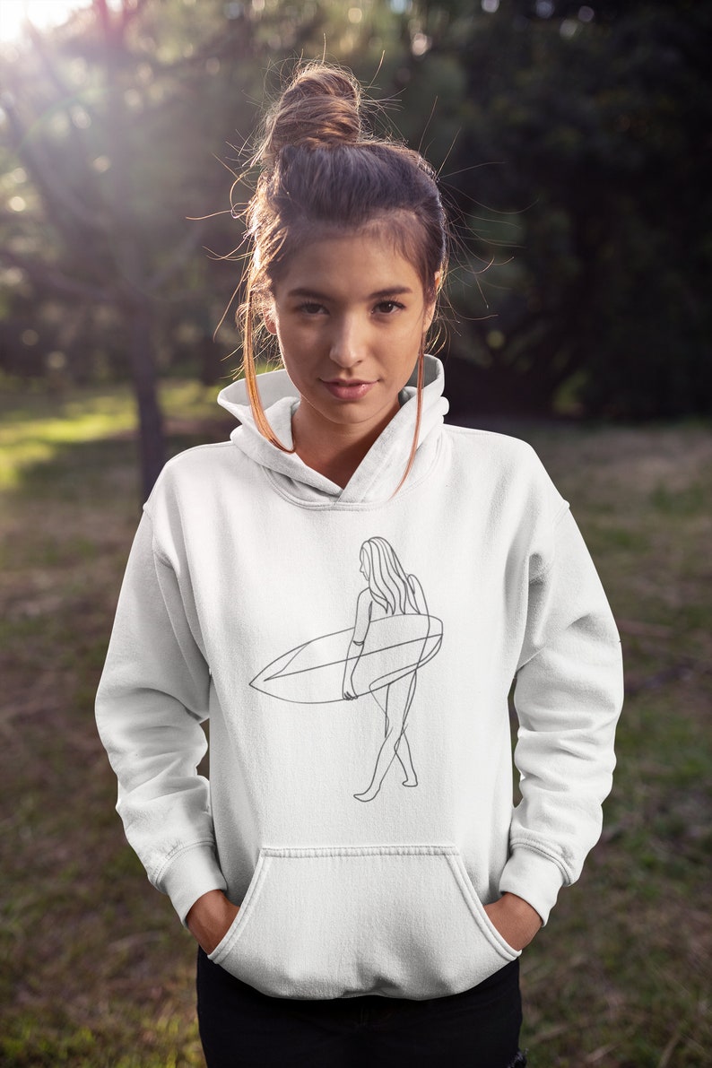 May include: White hoodie with a line drawing of a woman holding a surfboard. The drawing is in black and white.