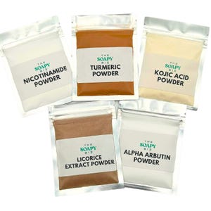 May include: Five small, clear, resealable bags filled with different colored powders. Each bag has a white label with the text "The Soapy Biz" and the name of the powder: Nicotinamide, Turmeric, Kojic Acid, Licorice Extract, and Alpha Arbutin.