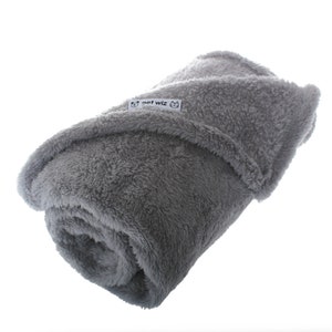 May include: A gray, soft, plush blanket with the text "pet wiz" on a white tag.