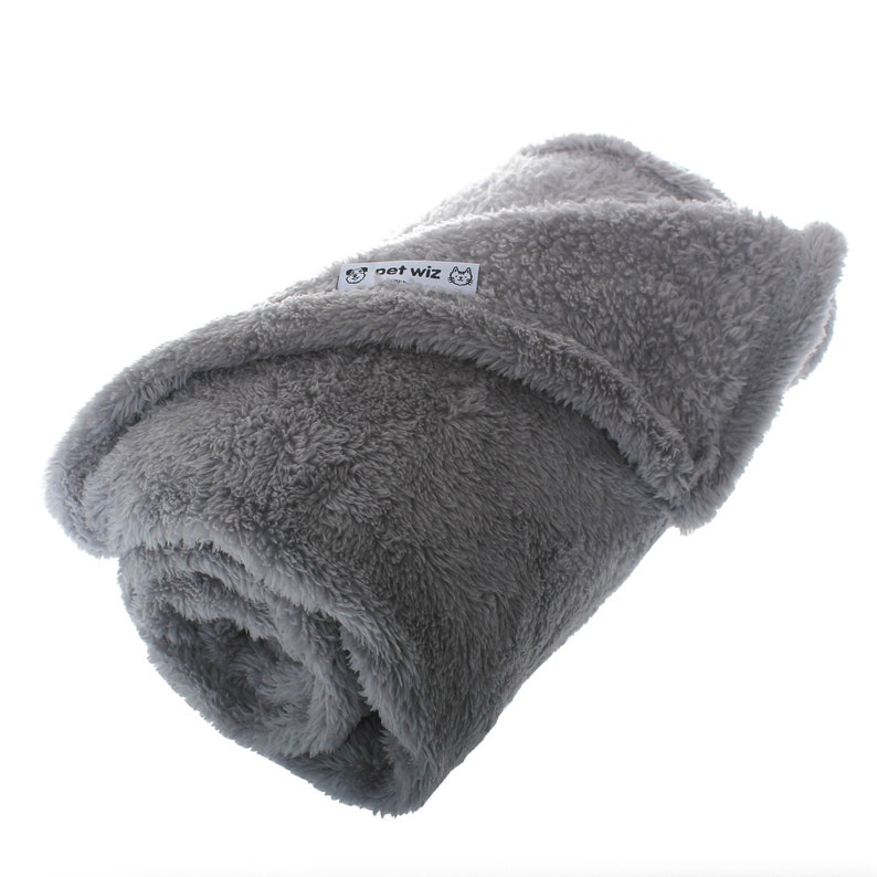 May include: A gray, soft, plush blanket with the text "pet wiz" on a white tag.