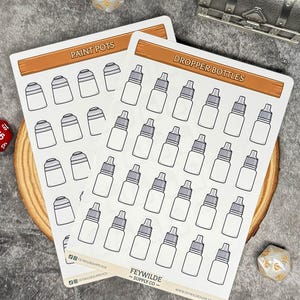 May include: Two white sticker sheets featuring illustrations of paint pots and dropper bottles. Each sheet has a brown banner at the top with the text "PAINT POTS" and "DROPPER BOTTLES". The brand name "FEYWILDE - SUPPLY CO -" is printed at the bottom.