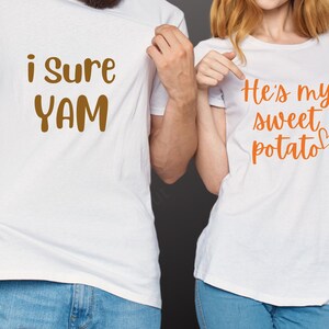 May include: A couple's matching t-shirts. The first shirt is white with the text "i sure YAM" in brown. The second shirt is white with the text "He's my sweet potato" in orange.