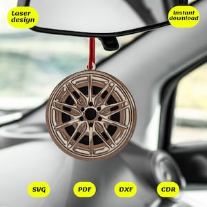 Könnte beinhalten: Ein hölzerner Autoreifen-Anhänger, der an einem Rückspiegel in einem Auto hängt. Der Anhänger ist braun mit einem silbernen Rand und Speichen. Der Text "Laser design" und "Sofort-Download" ist auf dem Bild zu sehen. Der Text "SVG, PDF, DXF, CDR" ist ebenfalls auf dem Bild zu sehen.