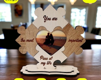Puede incluir: Un marco de rompecabezas de madera con un recorte en forma de corazón para una foto. El marco está hecho de cuatro piezas, cada una con una inscripción diferente: "You are", "the most", "important", y "Piece of my life".