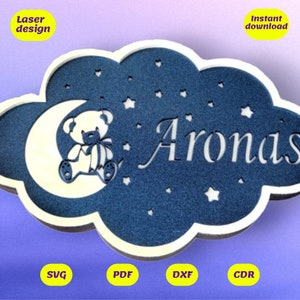 Peut inclure: Un nuage bleu avec des étoiles blanches et une lune croissante blanche avec un ours en peluche assis dessus. Le nom "Aronas" est écrit en blanc à l'intérieur du nuage. L'image est pour une découpe au laser.