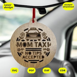 May include: A wooden car air freshener with the text "MOM TAXI NO TIPS ACCEPTED" and a small car graphic. The air freshener is hanging from a rearview mirror in a car.