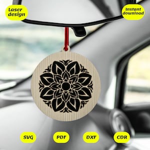 Può includere: Un profumatore per auto in legno con un design a mandala nero. Il profumatore è appeso allo specchietto retrovisore di un'auto. Il testo "Laser design" e "Download immediato" è visibile nell'immagine. I file inclusi sono SVG, PDF, DXF e CDR.