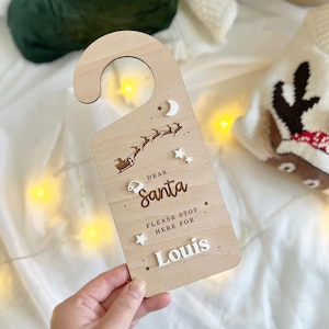 May include: Wooden door hanger with a Santa Claus design and the text "Dear Santa, Please stop here for Louis".