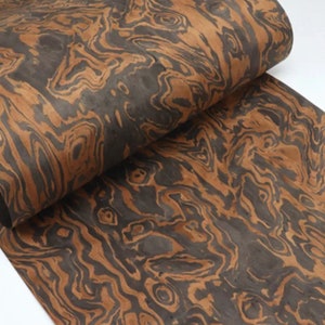 May include: A sheet of wood veneer with a brown and black marbled pattern. The wood has a unique and intricate grain.